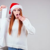 person in Santa Hat holding a long gift list