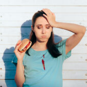 Unhappy woman with ketchup on shirt needs a stain removal chart