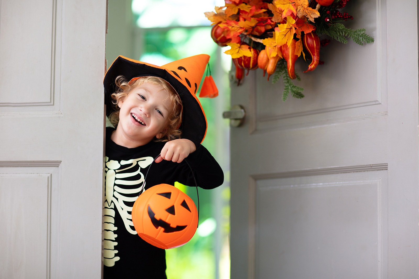 Little girl in halloween costume trick or treat at door