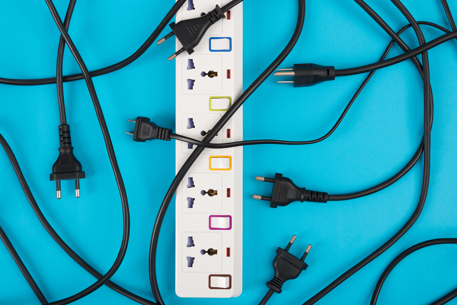 A power strips and electrical cords on a tuquoise background